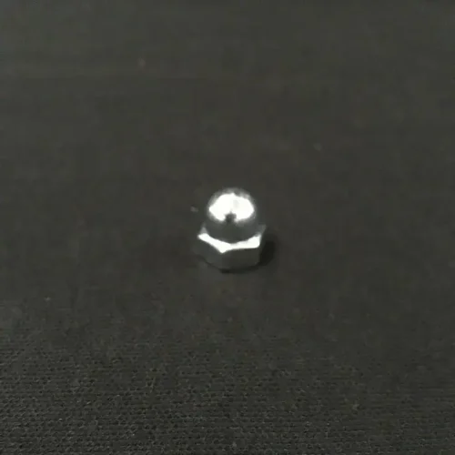 Bolt securing parts of QRC Karts, precision hardware for go-kart racing equipment, on a black surface.